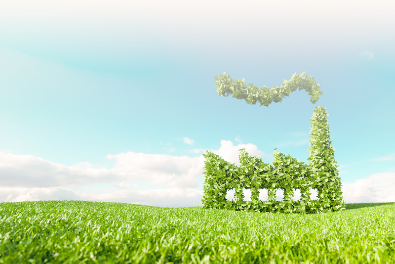 Green field with blue sky and a factory made out of leaves